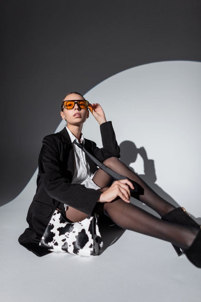 Cool beautiful glamorous woman with yellow glasses in fashion ou